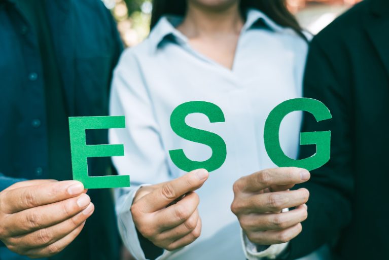 Három személy keze tartja az E, S és G betűket, szimbolizálva, hogy az OkosHACCP az ESG célok eléréséhez nyújt megoldást.